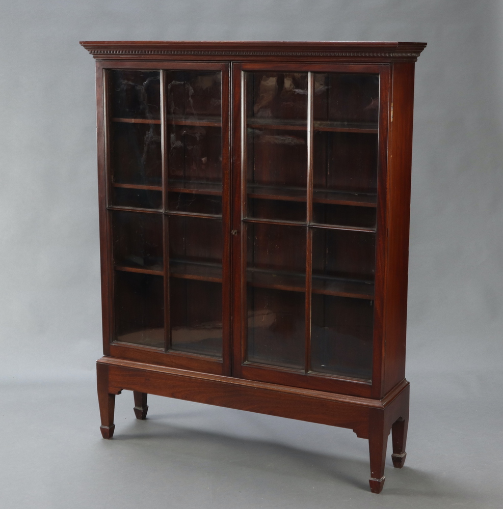 A 19th Century mahogany bookcase with moulded and dentil cornice, fitted adjustable shelves enclosed