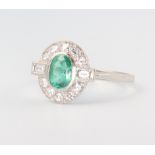 A white metal stamped Plat. oval emerald and baguette and brilliant cut diamond cluster ring, the