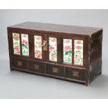 A Chinese hardwood cabinet, fitted shelves enclosed by a pair of folding panelled doors set floral