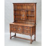 A 17th Century style carved oak dresser in the Ipswich manner, the back with pierced and moulded