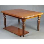 A Victorian style mahogany extending dining table raised on turned and fluted supports with 1