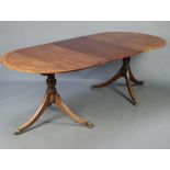 A Georgian style crossbanded mahogany D end dining table with 1 extra leaf, raised on pillar and