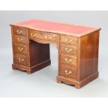 An Edwardian mahogany kneehole pedestal desk with red inset writing surface above 1 long and 8 short