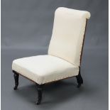 A Victorian nursing chair upholstered in white material, raised on turned ebonised supports 78cm h x