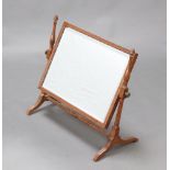 A 1920's rectangular bevelled plate dressing table mirror contained in a light oak swing frame