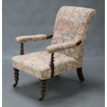 A Victorian mahogany open armchair upholstered in pink floral material, raised on spiral turned