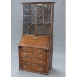 A 19th Century oak bureau bookcase the later associated top fitted shelves enclosed by astragal