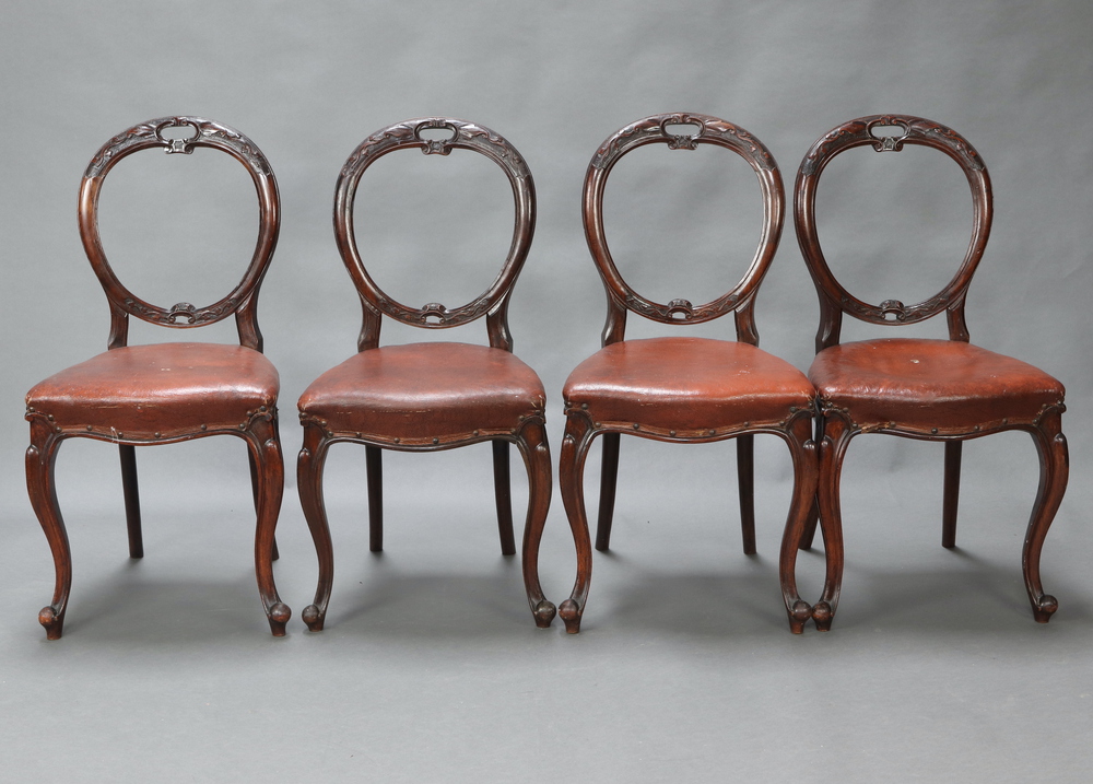 A set of 4 Victorian carved mahogany balloon back and serpentine shaped dining chairs with