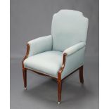 An Edwardian inlaid mahogany armchair upholstered in light blue material, raised on square tapered