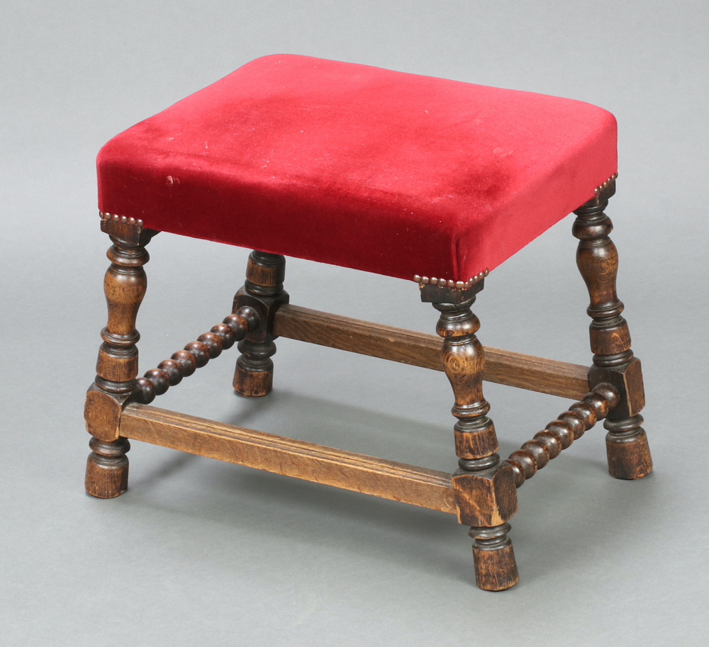 An 18th Century style rectangular oak framed stool, the seat upholstered in red material, raised