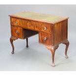 A walnut writing table with green inset writing surface above 1 long and 2 short drawers, raised