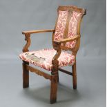 A Victorian Art Nouveau carved oak open arm chair, the shield shaped back and overstuffed seat