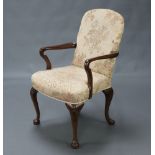 A 1940/50's Queen Anne style walnut open armchair, the seat and back upholstered in yellow floral