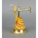An 18th/19th Century brass wax jack, raised on a circular base 7cm x 9cm diam.
