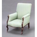 An Edwardian show frame mahogany armchair upholstered in green material, raised on cabriole supports