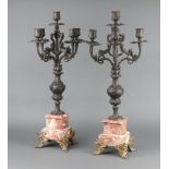 A pair of 19th Century Continental spelter 5 light candelabrum raised on pink veined marble bases