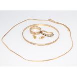 A 9ct yellow gold bangle, a wedding band, a necklace 45cm, together with a squashed gem set ring, 14