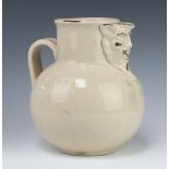 A Victorian crackle glazed Earthenware jug with mythical mask spout and simple handle 26cm