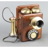 A wall mounting telephone contained in a mahogany case 9cm x 24cm x 16cm