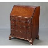 A Georgian style mahogany bureau of shaped outline and with canted corners, the fall front revealing