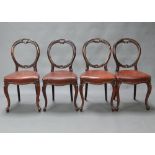 A set of 4 Victorian carved mahogany balloon back and serpentine shaped dining chairs with