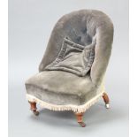 A Victorian metal framed nursing chair upholstered in blue buttoned material, raised on turned