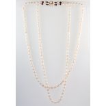 A baroque cultured pearl double strand necklace with a 14ct yellow gold pearl and sapphire set clasp