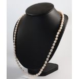 A baroque cultured pearl necklace with garnet terminals 64cm, having a 9ct yellow gold clasp