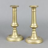 A pair of 18th/19th Century brass candlesticks raised on circular bases with ejectors 23cm x 11cm