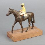 A spelter figure of a race horse with jockey up on a wooden base 14cm x 12cm x 6cm