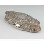 A Victorian silver serpentine trinket box decorated with scrolls and flowers and engraved