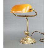 A reproduction brass bank lamp with amber glass shade, on a gilt metal base 40cm x 34cm