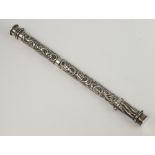 A Continental cylindrical repousse white metal needle and pin holder decorated with scrolls 22cm