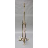 An Art Nouveau adjustable brass standard lamp with pineapple finial, raised on outswept supports