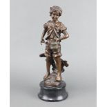 A bronze figure of a standing boy with fish and creel, raised on a circular black marble base 45cm h
