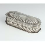 A Victorian rounded rectangular repousse silver trinket box with demi-fluted decoration London 1887,