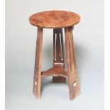 A Liberty style circular oak Art Nouveau 2 tier occasional table raised on pierced supports with