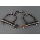 A pair of Hiatt handcuffs and key marked 104