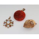 A 9ct yellow gold opal and garnet pendant, a yellow metal pendant and a hardstone pendant