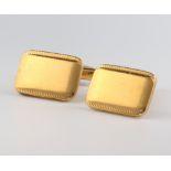 A pair of yellow metal engine turned cufflinks