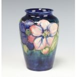 A Walter Moorcroft blue ground baluster vase decorated the clematis pattern with paper label and