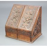 An Anglo Indian Victorian carved hardwood stationery box of wedge form and having a stepped fitted