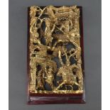 A Chinese carved and pierced gilt plaque depicting mounted warriors 27cm x 15cm