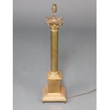 A gilt metal table lamp in the form of a reeded column with Corinthian capital, raised on a square