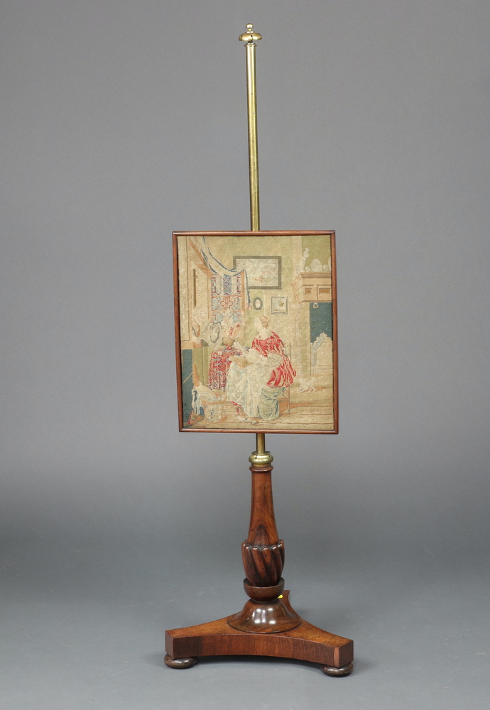 A rosewood pole screen with Berlin woolwork panel, raised on a baluster turned column and tripod