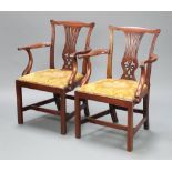 A pair of Edwardian Chippendale style open arm chairs with vase shaped slat backs and upholstered
