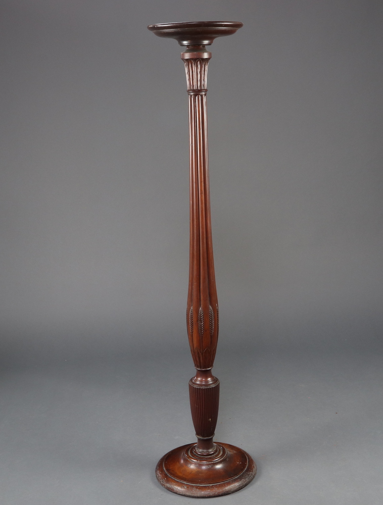 A William IV turned mahogany bedpost torcher with saucer top, raised on a turned column and