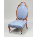 A Victorian carved mahogany show frame nursing chair upholstered in blue material, raised on