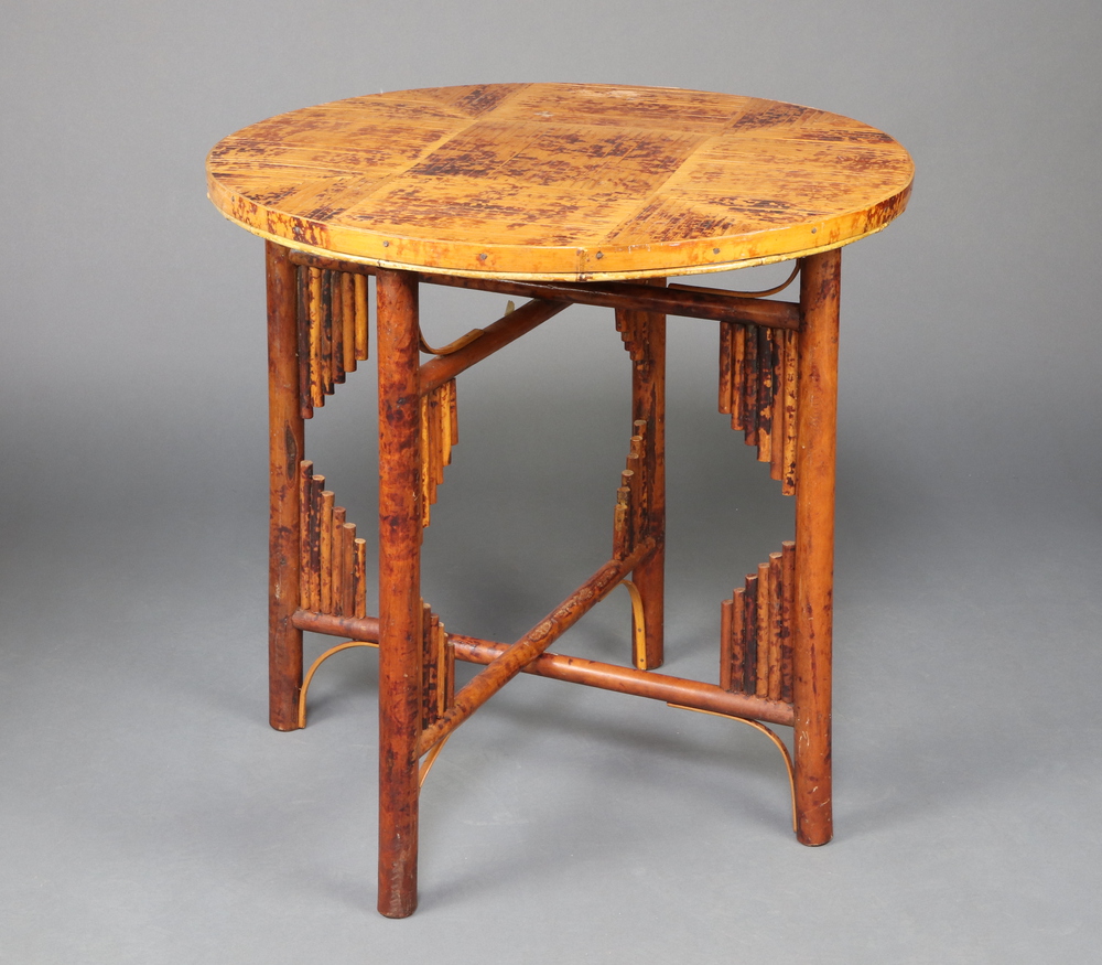 A 1930's Art Deco circular folding bamboo table raised on turned supports with X framed stretcher