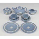 A Wedgwood blue Jasper miniature tea set comprising teapot and lid, sugar bowl and lid, milk jug,